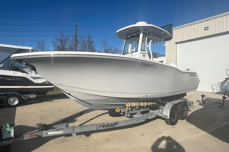 The Image of 2024 Tidewater 232 LXF boat on trailer, parked outdoors under clear blue sky. - 0