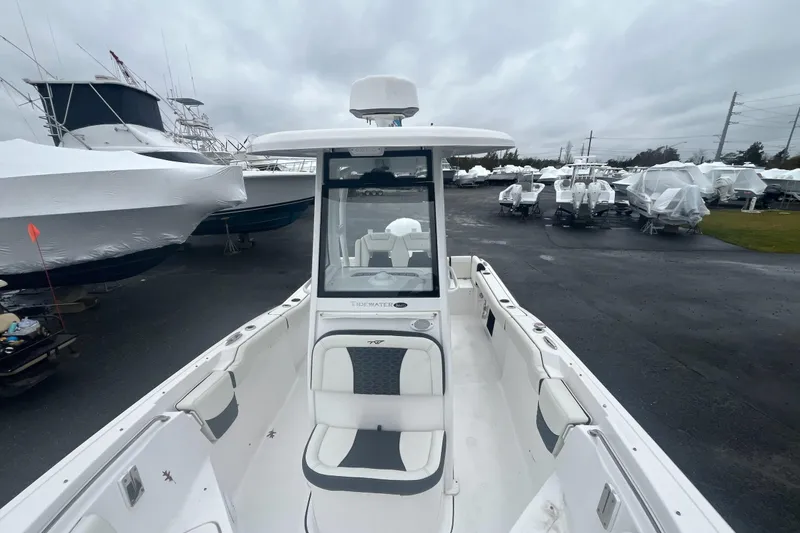 Slide: The Image of 2024 Tidewater 232 LXF boat in storage yard, surrounded by covered vessels. - 13