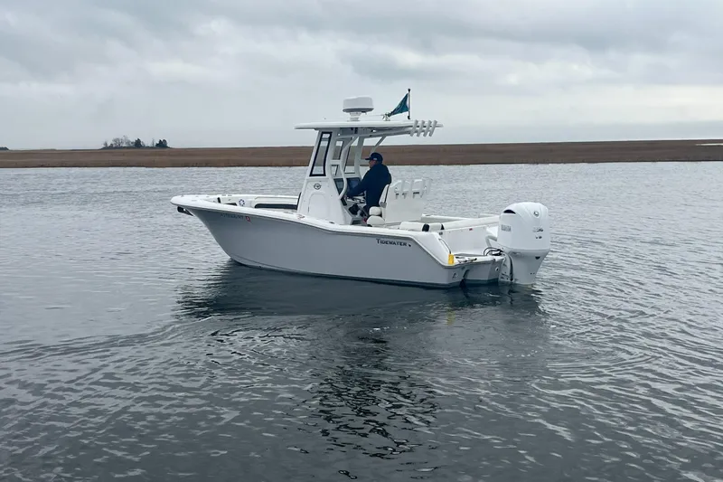 Slide: The Image of 2024 Tidewater 232 LXF boat on calm water, overcast sky in the background. - 5