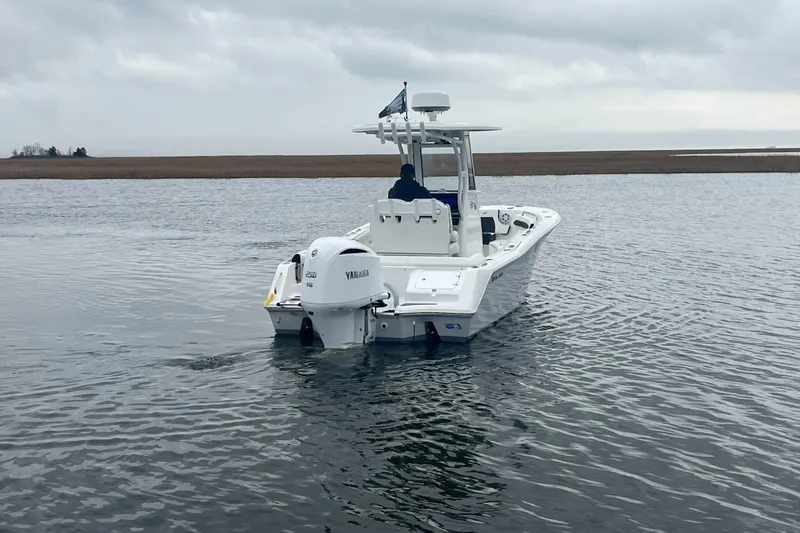 Slide: The Image of 2024 Tidewater 232 LXF boat on calm water, rear view with Yamaha engine. - 8