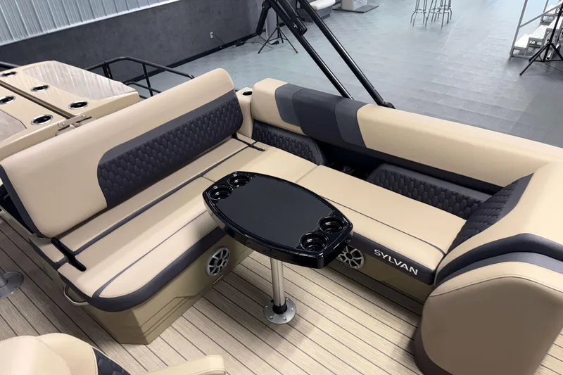 Slide: The Image of Luxurious 2026 Sylvan L3 DLZ Bar boat interior with beige seating and black table. - 16