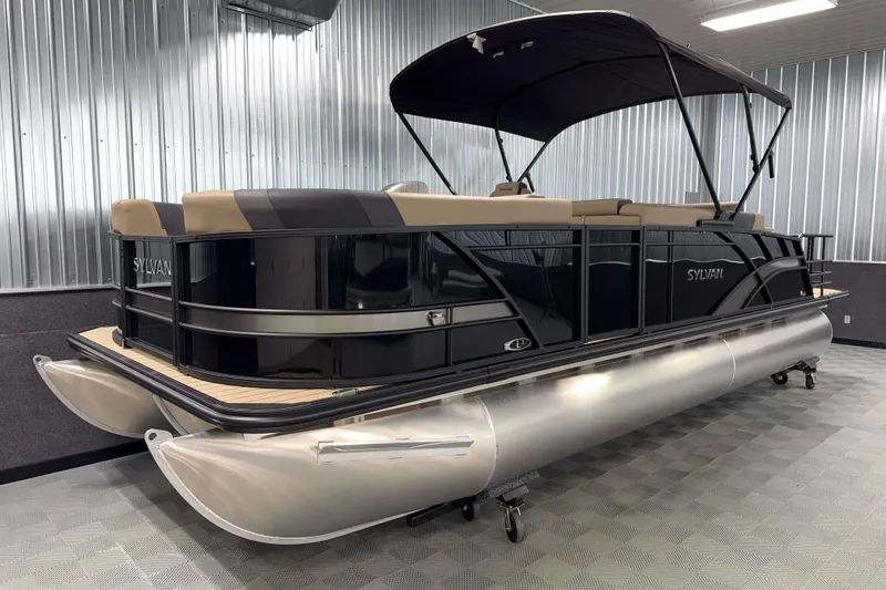 Slide: The Image of 2026 Sylvan L3 DLZ Bar pontoon boat in a showroom with sleek design. - 24