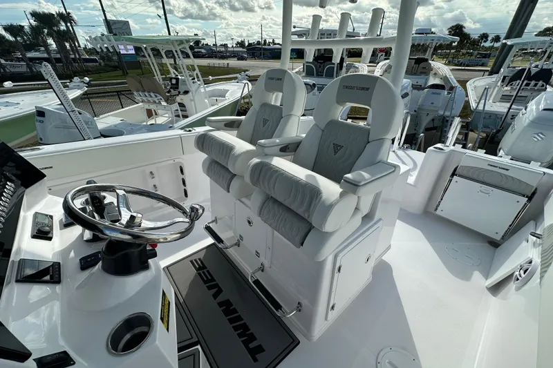 Slide: The Image of 2026 Twin Vee 280 GFX2 CC boat interior with dual captain's chairs and steering console. - 11