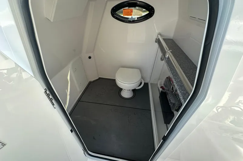 Slide: The Image of Interior of 2026 Twin Vee 280 GFX2 CC boat bathroom with toilet and storage. - 9