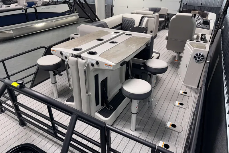 Slide: The Image of 2026 Sylvan L3 DLZ Bar pontoon boat interior with bar stools and table setup. - 19