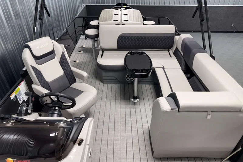 Slide: The Image of 2026 Sylvan L3 DLZ Bar pontoon boat interior with plush seating and steering console. - 7