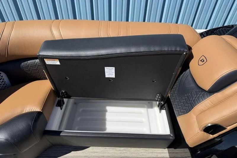 Slide: The Image of Open storage compartment in 2026 Premier 230 Intrigue RF boat with tan and black seating. - 12