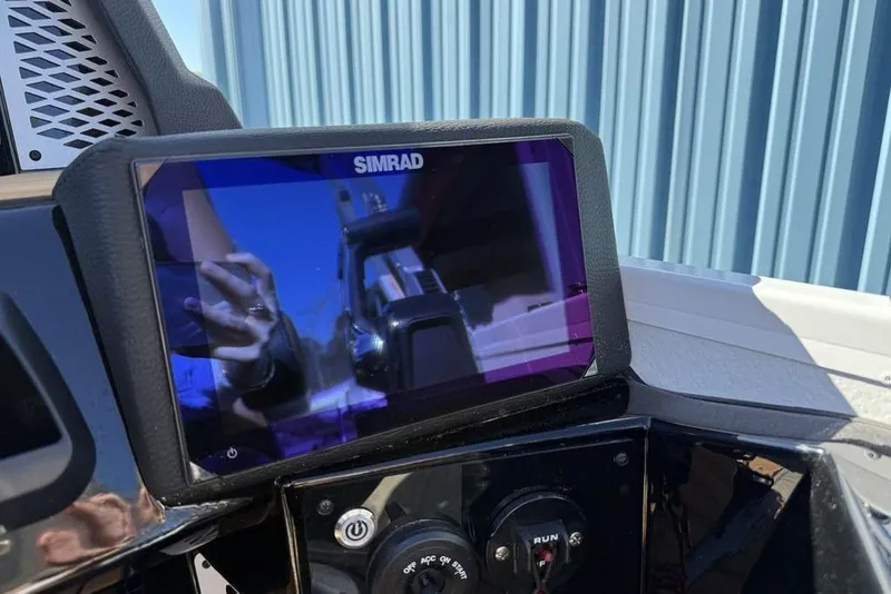 Slide: The Image of Simrad display on 2026 Premier 230 Intrigue RF boat dashboard, reflecting surroundings. - 24