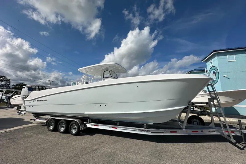 The Image of 2026 Twin Vee 340 GFX2 CC boat on trailer under blue sky. - 1