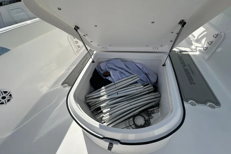 Slide: The Image of Open storage compartment on 2026 Twin Vee 340 GFX2 CC boat with metal poles inside. - 10