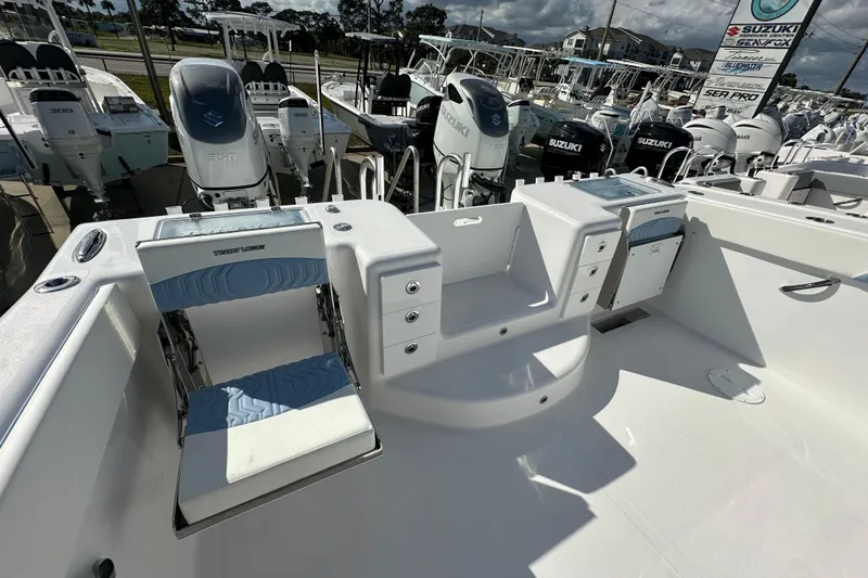 Slide: The Image of 2026 Twin Vee 340 GFX2 CC boat interior with seating and Suzuki engines in background. - 15