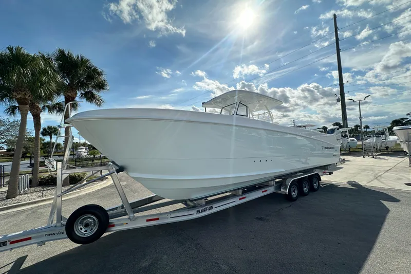 Slide: The Image of 2026 Twin Vee 340 GFX2 CC boat on trailer under sunny sky. - 3