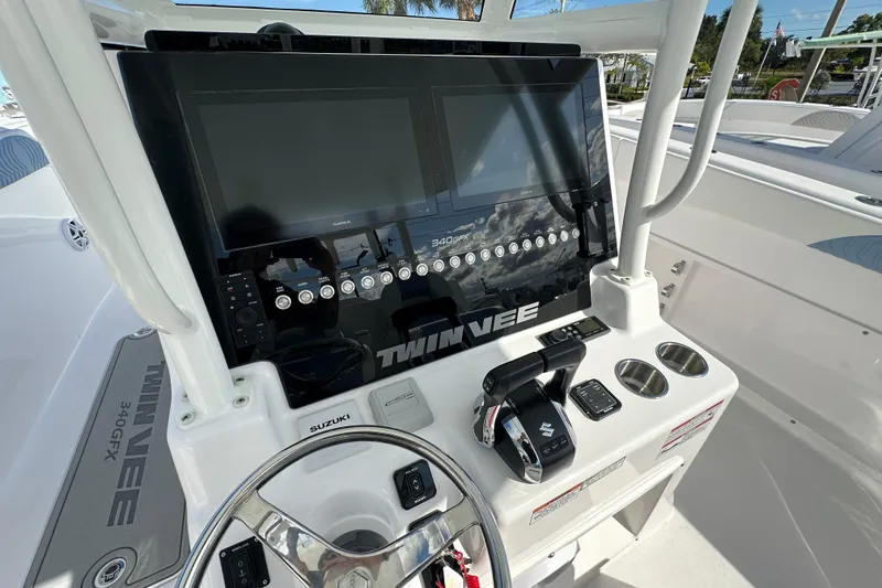 Slide: The Image of 2026 Twin Vee 340 GFX2 CC boat dashboard with steering wheel and control panel. - 7