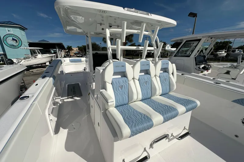 Slide: The Image of 2026 Twin Vee 340 GFX2 CC boat interior with blue and white seating, docked at marina. - 14