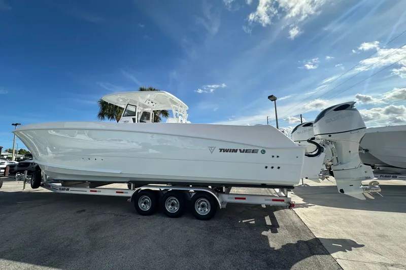 Slide: The Image of 2026 Twin Vee 340 GFX2 CC boat on trailer, featuring dual outboard engines. - 4
