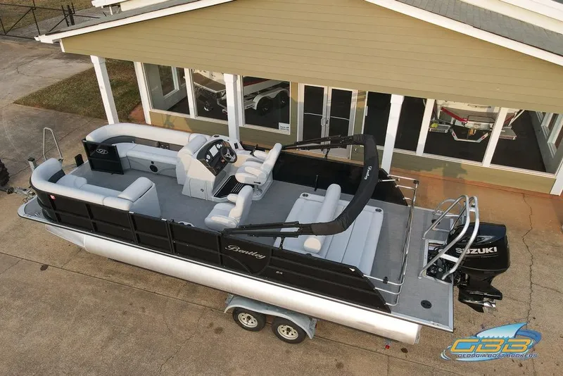 The Image of 2022 Bentley 243 Swingback pontoon boat with Suzuki engine, parked on trailer. - 1