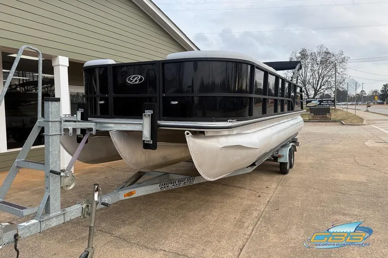 Slide: The Image of 2022 Bentley 243 Swingback pontoon boat on trailer, parked outside a building. - 10