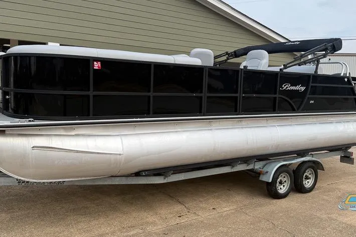Slide: The Image of 2022 Bentley 243 Swingback pontoon boat on trailer, black exterior, parked outdoors. - 11