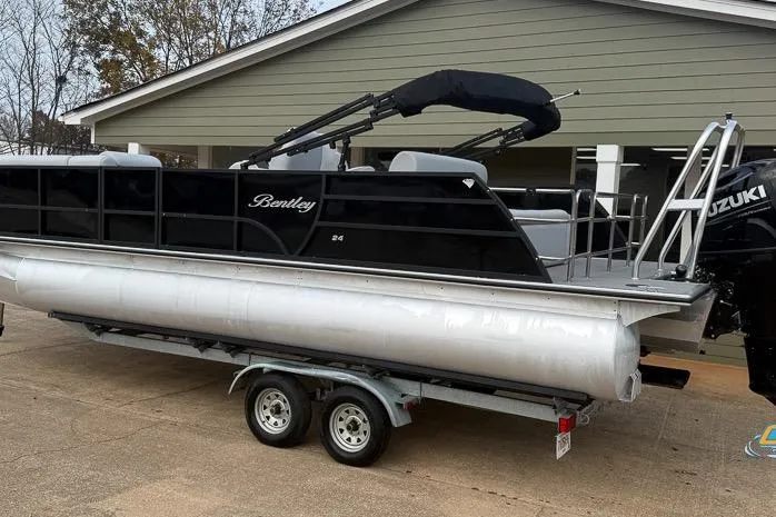 Slide: The Image of 2022 Bentley 243 Swingback pontoon boat on trailer, parked near a house. - 12