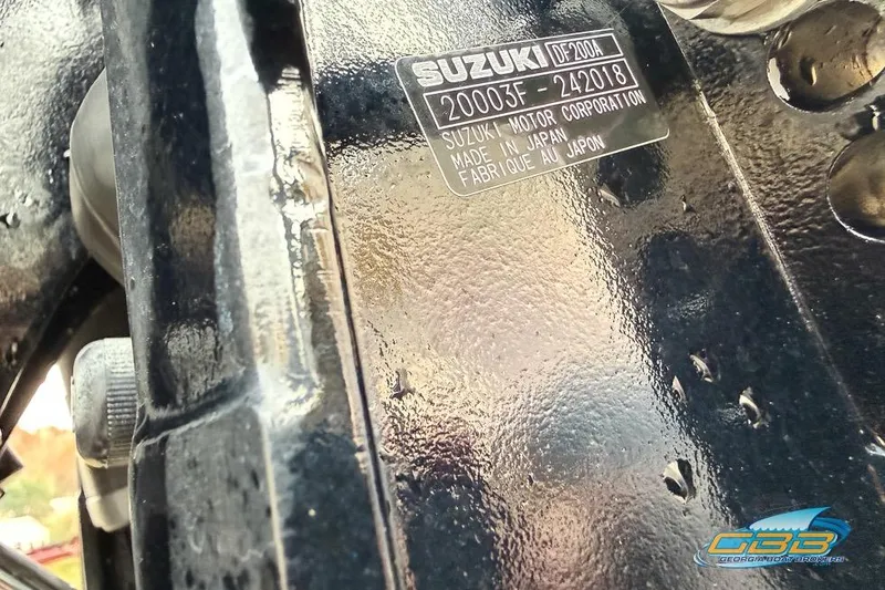 Slide: The Image of Close-up of a Suzuki engine part with identification plate, featuring a glossy black finish. - 27