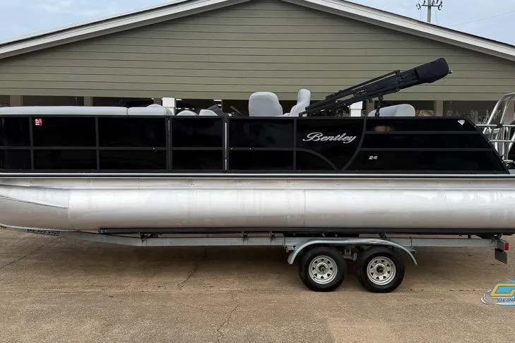 Slide: The Image of 2022 Bentley 243 Swingback pontoon boat on trailer, parked outdoors. - 6