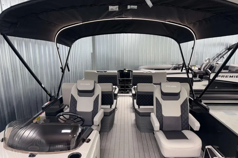 Slide: The Image of 2026 Sylvan L3 RLZ pontoon boat with modern seating and canopy in showroom. - 8