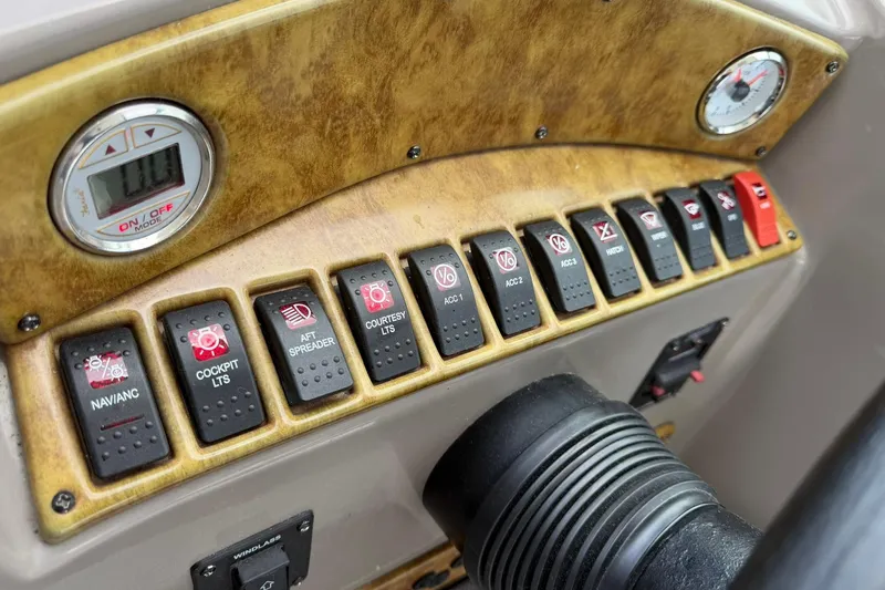Slide: The Image of Control panel of 2007 Rinker 370 Express Cruiser Hard Top with various switches and gauges. - 13