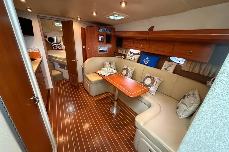 Slide: The Image of 2007 Rinker 370 Express Cruiser interior with cozy seating and elegant wood finishes. - 16