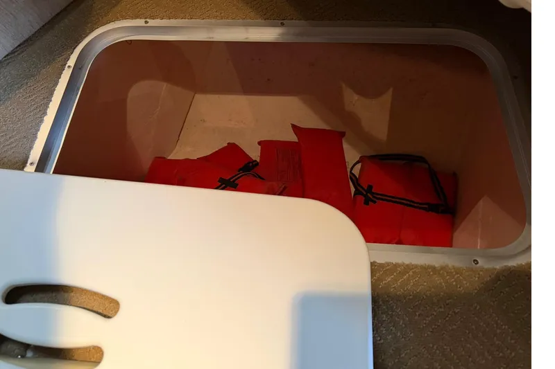 Slide: The Image of Storage compartment with red life jackets on a 2007 Rinker 370 Express Cruiser Hard Top. - 19