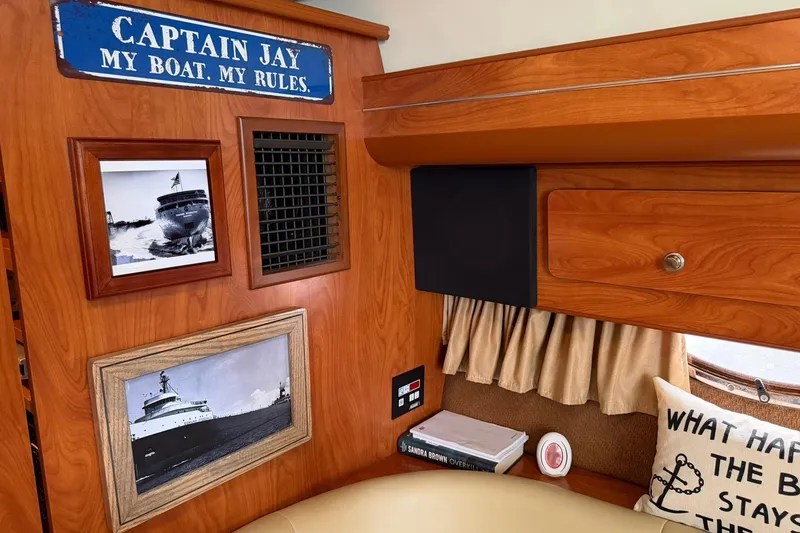 Slide: The Image of Interior of 2007 Rinker 370 Express Cruiser with nautical decor and framed boat photos. - 20