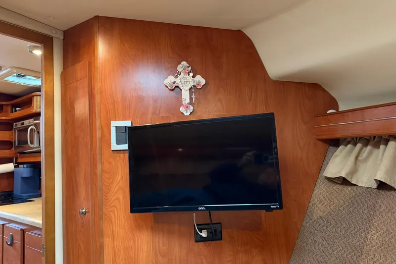 Slide: The Image of Interior of 2007 Rinker 370 Express Cruiser with mounted TV and wooden cabinetry. - 25