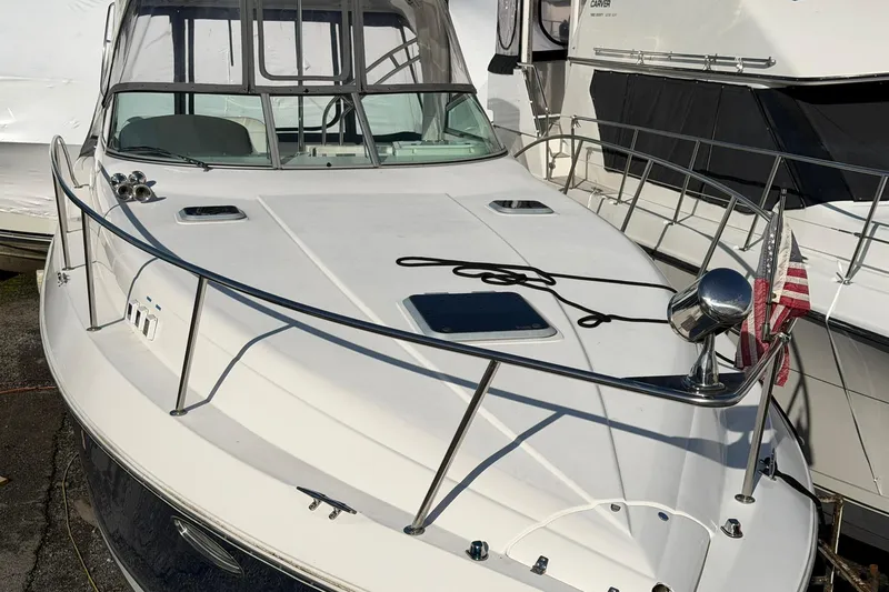 Slide: The Image of 2007 Rinker 370 Express Cruiser Hard Top docked, featuring sleek design and American flag. - 6