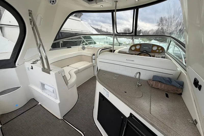 Slide: The Image of 2007 Rinker 370 Express Cruiser Hard Top interior with helm, seating, and kitchenette. - 8