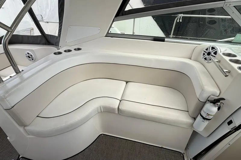 Slide: The Image of 2007 Rinker 370 Express Cruiser Hard Top interior with white seating and cup holders. - 9