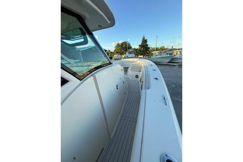 Slide: The Image of 2020 Grady-White Canyon 376 boat with triple outboard engines in a marina. - 12
