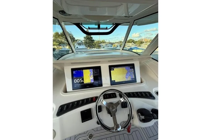 Slide: The Image of 2020 Grady-White Canyon 376 interior with kitchenette, microwave, and fishing rods. - 23