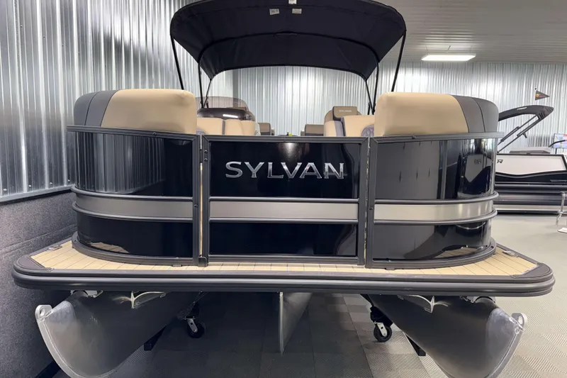 Slide: The Image of 2026 Sylvan L3 RLZ pontoon boat in showroom, featuring sleek black design and beige seating. - 25