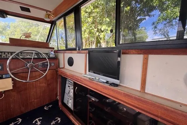 Slide: The Image of 1987 Carver 32 Aft Cabin Motor Yacht interior with steering wheel and TV setup. - 21