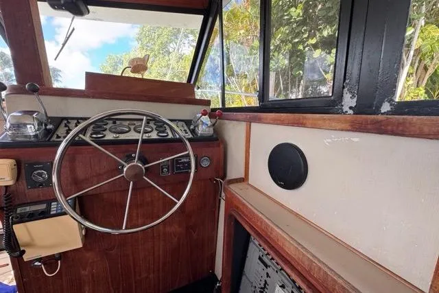 Slide: The Image of 1987 Carver 32 Aft Cabin Motor Yacht helm with steering wheel and control panel. - 22