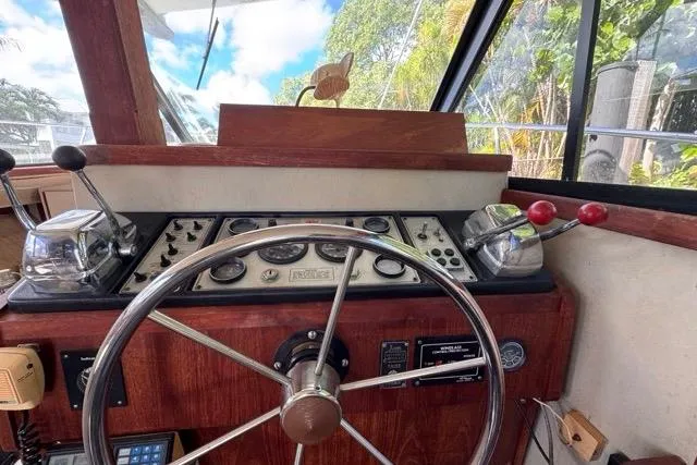 Slide: The Image of 1987 Carver 32 Aft Cabin Motor Yacht helm with steering wheel and control panel. - 23