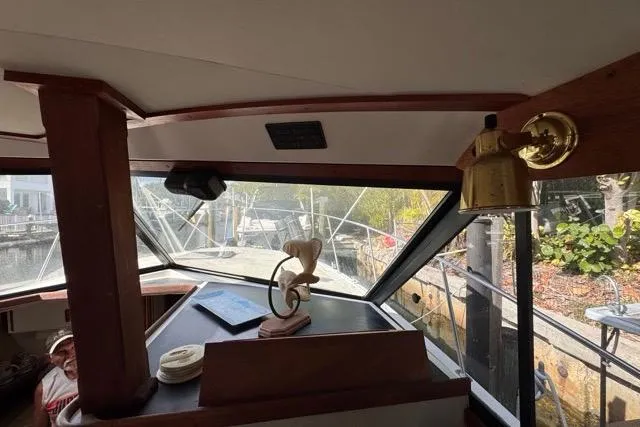 Slide: The Image of Interior view of 1987 Carver 32 Aft Cabin Motor Yacht with helm and brass lamp. - 25