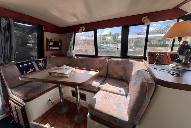 Slide: The Image of 1987 Carver 32 Aft Cabin Motor Yacht interior with cozy seating and dining area. - 26