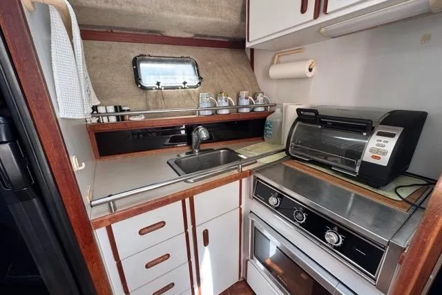 Slide: The Image of 1987 Carver 32 Aft Cabin Motor Yacht kitchen with sink, oven, and toaster. - 40