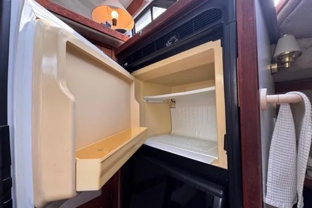 Slide: The Image of Open refrigerator inside 1987 Carver 32 Aft Cabin Motor Yacht, showcasing interior space. - 44