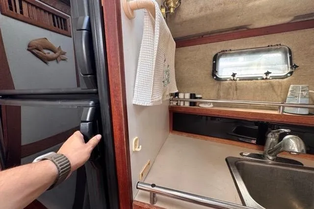 Slide: The Image of 1987 Carver 32 Aft Cabin Motor Yacht kitchen with sink, window, and fridge. - 45