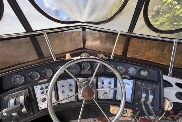 Slide: The Image of 1987 Carver 32 Aft Cabin Motor Yacht helm with steering wheel and control panel. - 61