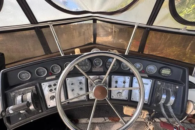 Slide: The Image of 1987 Carver 32 Aft Cabin Motor Yacht helm with gauges and steering wheel. - 62