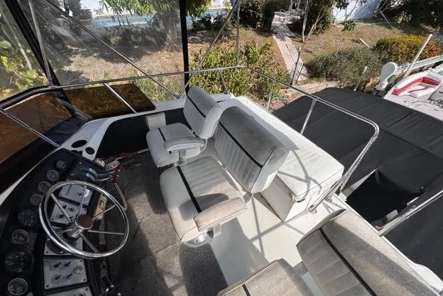 Slide: The Image of 1987 Carver 32 Aft Cabin Motor Yacht cockpit with steering wheel and seating area. - 63