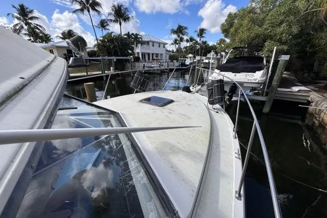Slide: The Image of 1987 Carver 32 Aft Cabin Motor Yacht docked in a scenic marina setting. - 64