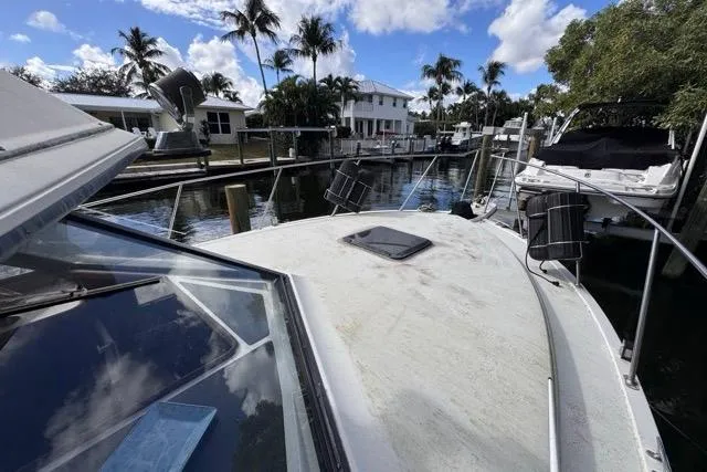 Slide: The Image of 1987 Carver 32 Aft Cabin Motor Yacht docked in a scenic canal setting. - 65